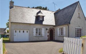a house with a white fence in front of it at 3 Bedroom Nice Home In Ploumilliau in Ploumilliau