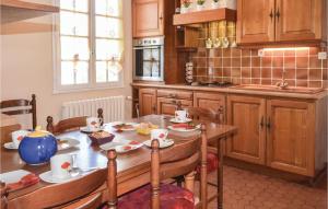 a kitchen with a wooden table with a blue vase on it at 3 Bedroom Nice Home In Ploumilliau in Ploumilliau
