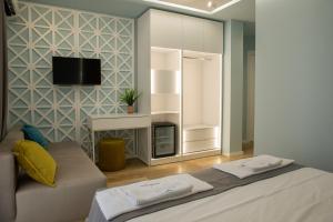 una stanza con un letto e una TV su una parete di Veranda Boutique Hotel a Vlorë