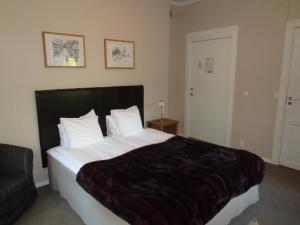 
a bedroom with a white bed and white walls at Hotell S:t Olof in Falköping
