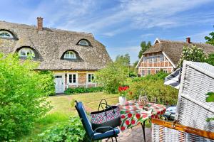 a patio with a table and chairs in front of a house at Landhaus Vilmnitz - Wohnung 8 in Vilmnitz