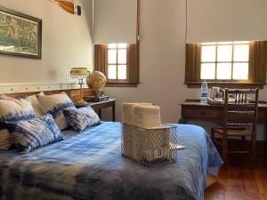 a bedroom with a bed and a desk and windows at Buenos Aires Rowing Club in Tigre