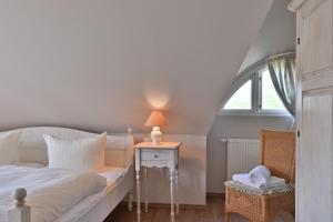 a bedroom with a bed and a table with a lamp at Landhaus Vilmnitz - Wohnung 10 in Vilmnitz