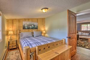 Grand Lake Home with Fireplace, Deck, Mountain Views في غراند ليك: غرفة نوم مع سرير مع اللوح الأمامي الخشبي