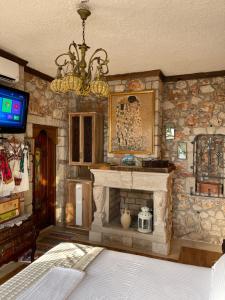 a living room with a fireplace and a chandelier at Solomon&Sons in Dhërmi