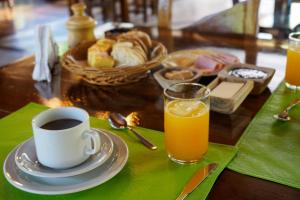 uma mesa com uma chávena de café e um copo de sumo de laranja em Reserva La Mision Mocona - Solo Adultos em Saltos del Moconá