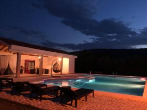 una piscina por la noche con sillas alrededor en Villa Paraiso, en Mostar