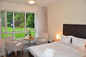 a hotel room with a bed and a table and chairs at Concorde Hotel Viktoria in Kronberg im Taunus