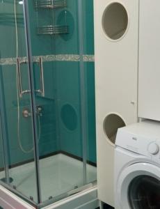 y baño con ducha y lavadora. en MÁRIA apartman en Balatonkeresztúr