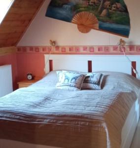 een slaapkamer met een groot bed en een schilderij aan de muur bij MÁRIA apartman in Balatonkeresztúr