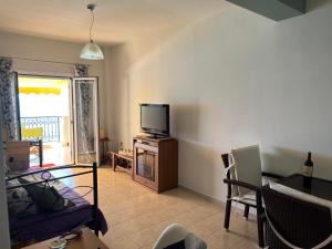 a living room with a tv and a couch at Cosy Apartment by the water, Agia Pelagia in Agia Pelagia