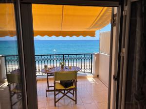 a balcony with a table and a view of the ocean at Cosy Apartment by the water, Agia Pelagia in Agia Pelagia