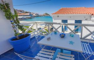 a table and chairs on a balcony with a view of the water at DEJA BLUE Maisonette ll in Kokkari