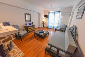 a living room with a couch and a table and chairs at DEJA BLUE Maisonette ll in Kokkari