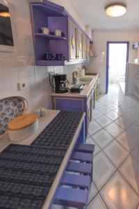 a kitchen with purple cabinets and a counter top at DEJA BLUE Maisonette ll in Kokkari