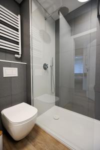 uma casa de banho com um WC branco e um chuveiro em Villa Park Apartament em Ostróda