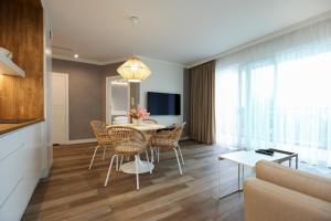 uma sala de estar com uma mesa e cadeiras e um sofá em Villa Park Apartament em Ostróda