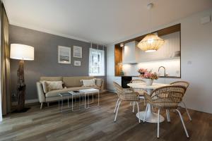a living room with a couch and a table and chairs at Villa Park Apartament in Ostróda