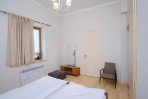 a bedroom with two beds and a chair and a mirror at Toon 55 in Gyumri