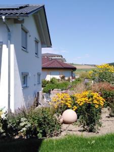 a house with a garden with yellow flowers at Eva's Ferienwohnung in Bonndorf im Schwarzwald