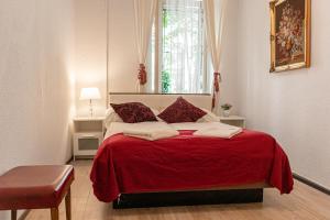 1 dormitorio con cama roja y manta roja en Timeless Red 1BR Apartment - Great for Longstays, en Viena