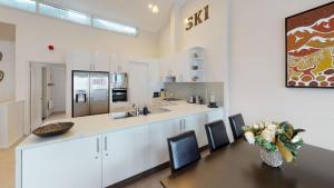 a kitchen with a table and chairs and a counter at Lodge Apartment 25 The Stables in Perisher Valley