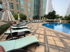 a row of lounge chairs next to a swimming pool at FIRST CLASS 2BR with full BURJ KHALIFA and FOUNTAIN VIEW in Dubai