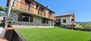 a yard with green grass in front of a building at Hotel l'Escapade in Beuil