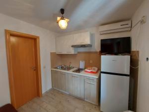 una pequeña cocina con nevera blanca y fregadero en Sweet Sea Apartments, en Pakoštane