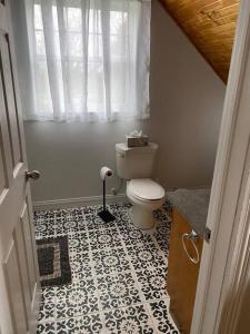 a bathroom with a toilet and a tile floor at Loft apartment in Kensington in Kensington
