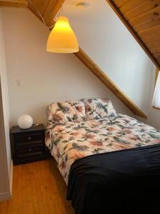 a bedroom with a bed and a lamp and a table at Loft apartment in Kensington in Kensington