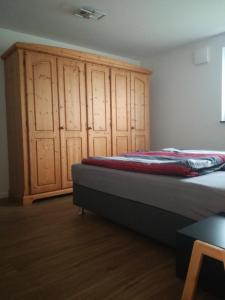 a bedroom with a bed and a wooden cabinet at Eva's Ferienwohnung in Bonndorf im Schwarzwald