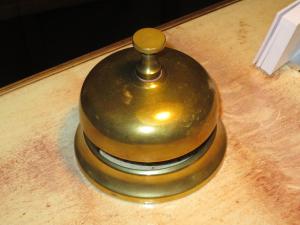 a metal bell sitting on top of a wooden table at Hotell S:t Olof in Falköping