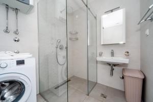 a bathroom with a washing machine and a sink at Soho city apartment in Bar