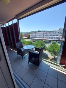 balcón con mesa y sillas y ventana grande en Apartment Hanna en Koper