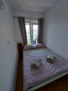 um quarto com uma cama com lençóis roxos e uma janela em Apartment Hanna em Koper