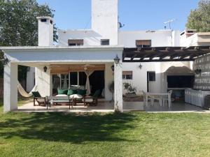 ein Haus mit einer Terrasse mit einem Tisch und Stühlen in der Unterkunft Casa Trinidad in Ciudad Lujan de Cuyo
