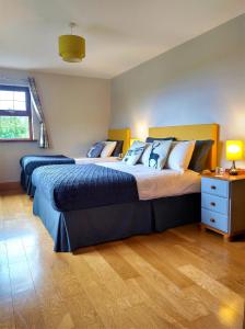 a bedroom with two beds and a nightstand with two lamps at Glenn Eireann House in Cushendun