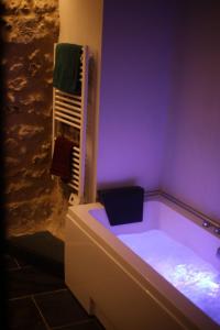 a bathroom with a bath tub with a towel at La Montrieuse, Chambre individuelle avec sauna et baignoire spa in Naveil