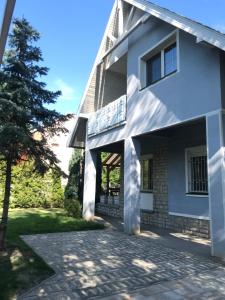 Biały dom z kamiennym podjazdem w obiekcie Rita Apartman Balatonszéplak w Siófoku