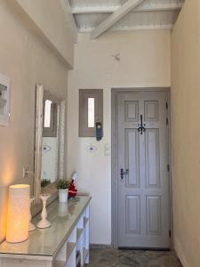 ein Badezimmer mit einer weißen Tür und einem Waschbecken in der Unterkunft Καλοκαιρινό σπίτι στο Σίγρι in Sígrion