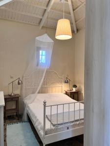 ein Schlafzimmer mit einem weißen Bett und einem Fenster in der Unterkunft Καλοκαιρινό σπίτι στο Σίγρι in Sígrion