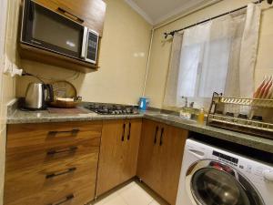 a kitchen with a washing machine and a microwave at Trendy House in Badr