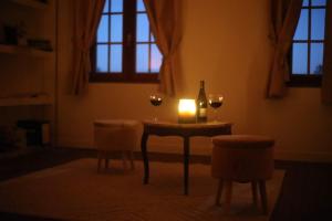 a table with two glasses of wine and a candle at La Montrieuse, Chambre individuelle avec sauna et baignoire spa in Naveil