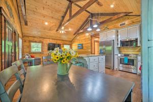 a kitchen with a table with a vase of flowers on it at Falling Star Eagletown Cabin with Hot Tub Pets OK in Eagletown