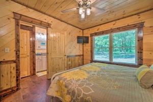 a bedroom with a bed and a ceiling fan at Falling Star Eagletown Cabin with Hot Tub Pets OK in Eagletown