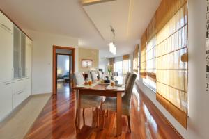 a kitchen and dining room with a wooden table and chairs at Majpruz Apartment Zadar in Zadar