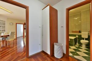 a bathroom with a toilet and a dining room at Majpruz Apartment Zadar in Zadar