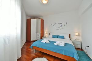 a bedroom with a blue bed with two towels on it at Majpruz Apartment Zadar in Zadar