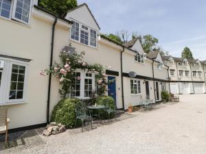 a row of white buildings with tables and chairs at 5 Wye Rapid Cottages in Ross on Wye